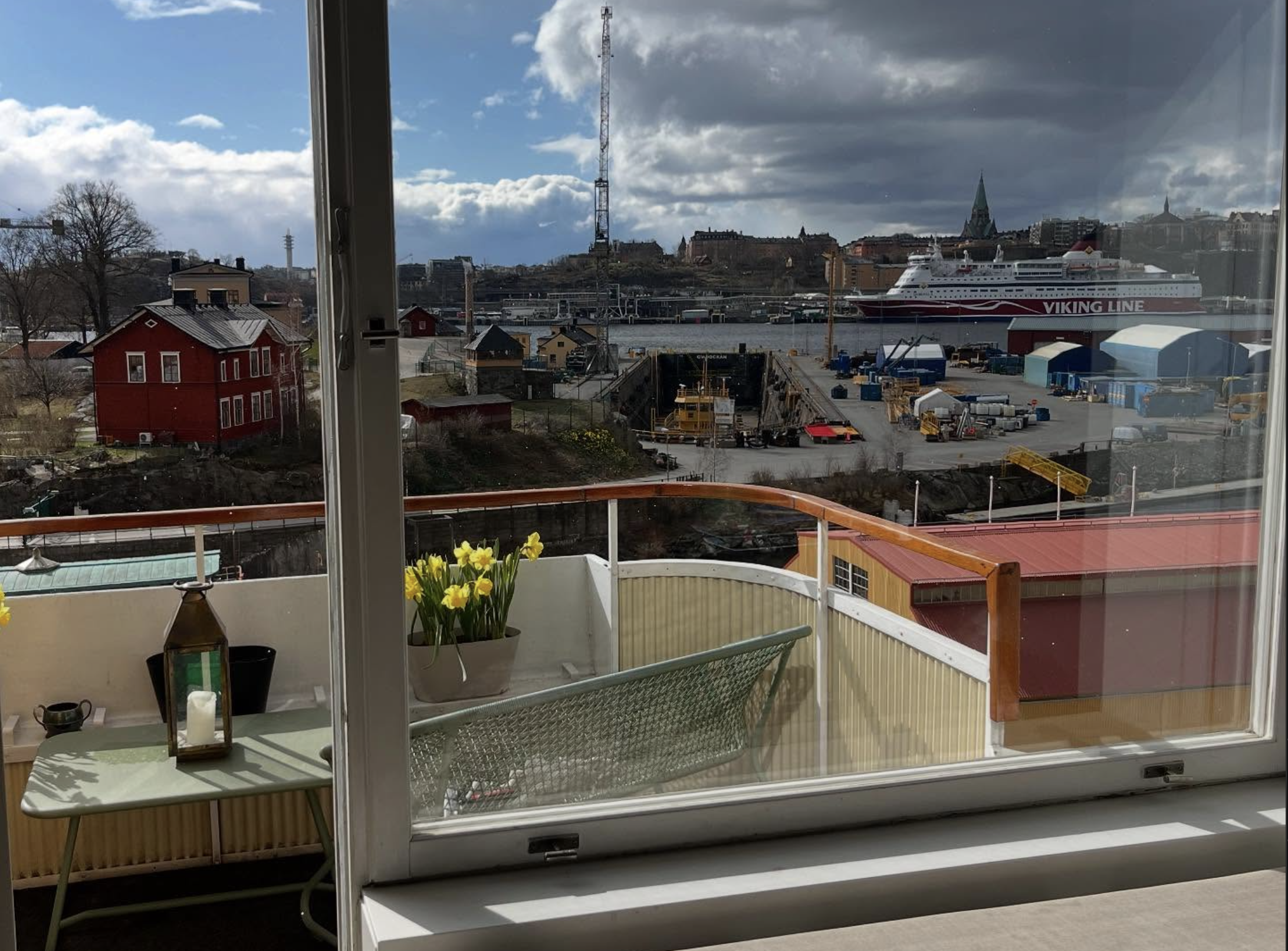 Stort fönster på Djurgården med utsikt över sjön och kryssningsbåt – professionell fönsterputs i Stockholm med vacker sjöutsikt.